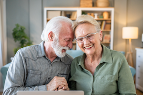 Life Assure Senior Woman Sitting In Chair And Laughing With Caregiver Nurse Blog